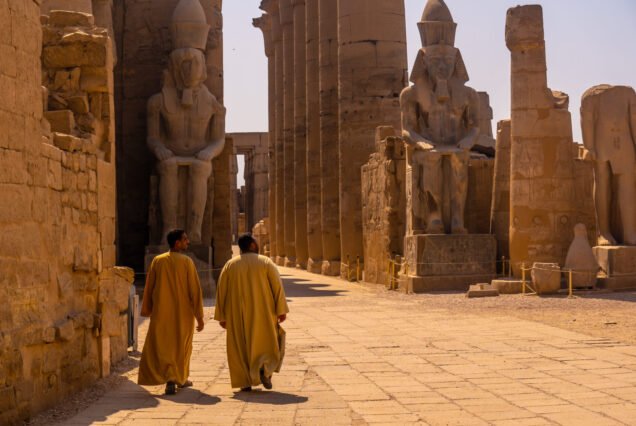 Two local men visiting the Egyptian Temple of Luxor and its precious column