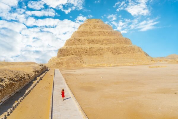 A young girl in a red dress walking in the Stepped Pyramid of Djoser